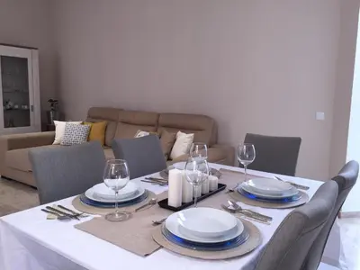 a dining room table with plates and wine glasses at Apartamento San Pedro in Cádiz