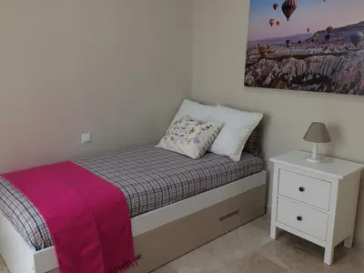 a small bedroom with a bed and a nightstand at Apartamento San Pedro in Cádiz