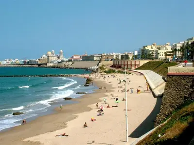 a group of people on a beach near the ocean at Apartamento San Pedro in Cádiz