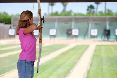 a young woman holding a bat on a baseball field at Aldiana Club Andalusien in Chiclana de la Frontera