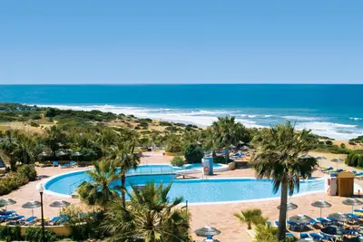 a view of a resort with a pool and the ocean at Aldiana Club Andalusien in Chiclana de la Frontera