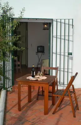 a wooden table and chair on a patio at Mesón de la Molinera in Arcos de la Frontera