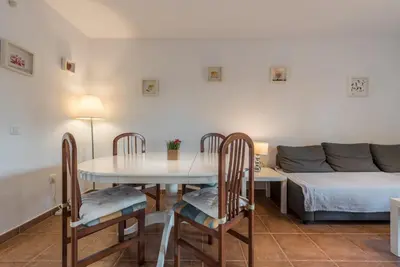 a dining room with a table and chairs and a couch at Apartamento Mijares in Chiclana de la Frontera