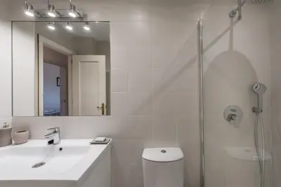 a white bathroom with a sink and a shower at Apartamento Mijares in Chiclana de la Frontera