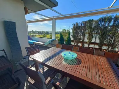 a wooden table with a blue bowl on it on a patio at artQhost Costa Ballena Penthouse Ocean and Golf views & Free Parking in Costa Ballena