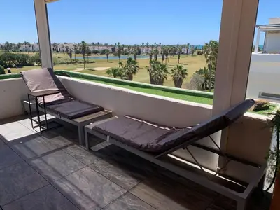 a balcony with a bathtub and a chair on a porch at artQhost Costa Ballena Penthouse Ocean and Golf views & Free Parking in Costa Ballena