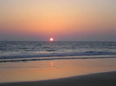 a sunset on the beach with the ocean at artQhost Costa Ballena Penthouse Ocean and Golf views & Free Parking in Costa Ballena