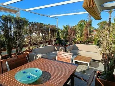 a patio with a wooden table and a couch at artQhost Costa Ballena Penthouse Ocean and Golf views & Free Parking in Costa Ballena