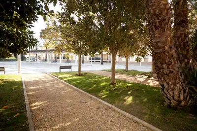 a park with benches and trees in a city at Ático Barrio de los Pescadores in Costa Ballena