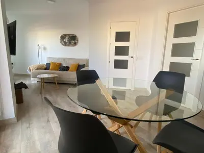 a living room with a glass table and chairs at Atico Infanta Eulalia in Sanlúcar de Barrameda
