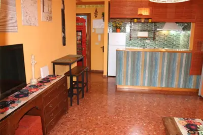 a room with a kitchen and a counter with stools at Apartamento La Venencia in Jerez de la Frontera