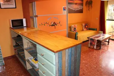 a room with a kitchen with a counter and a couch at Apartamento La Venencia in Jerez de la Frontera