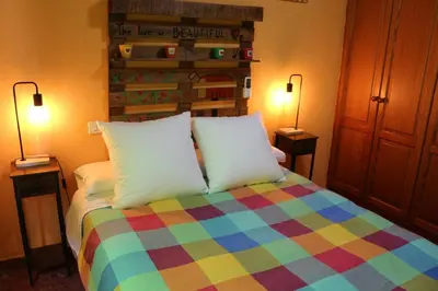 a bedroom with a colorful bed with two lamps at Apartamento La Venencia in Jerez de la Frontera