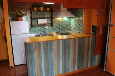a kitchen with a striped counter with a sink and a refrigerator at Apartamento La Venencia in Jerez de la Frontera