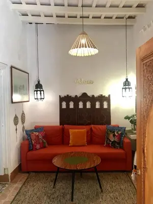 a living room with a red couch and a table at Casa Seven Jerez in Jerez de la Frontera