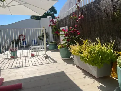 a patio with potted plants and a fence at Ancla Real Apartamentos Loft in El Puerto de Santa María
