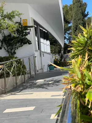 a white building with a fence and some plants at Ancla Real Apartamentos Loft in El Puerto de Santa María