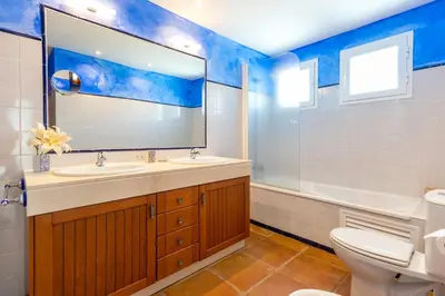 a bathroom with a sink and a toilet and a mirror at Villa Golf Sanlucar in Sanlúcar de Barrameda