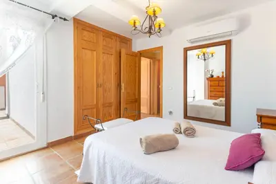 a bedroom with a white bed and a mirror at Villa Golf Sanlucar in Sanlúcar de Barrameda
