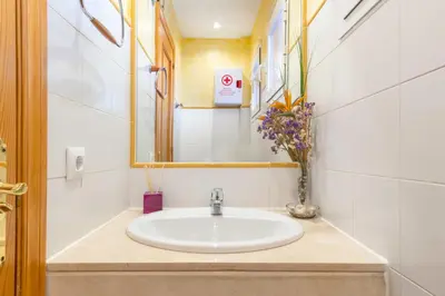 a bathroom with a sink and a vase of flowers at Villa Golf Sanlucar in Sanlúcar de Barrameda