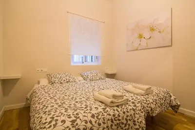 a bedroom with a bed with two towels on it at Apartamentos Aloha 2 Centro El Puerto de Santa Maria in El Puerto de Santa María