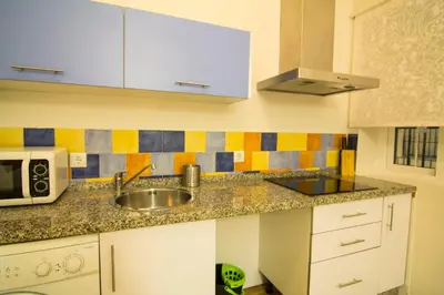 a kitchen with a sink and a microwave at Apartamentos Aloha 2 Centro El Puerto de Santa Maria in El Puerto de Santa María