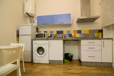 a kitchen with a washing machine and a microwave at Apartamentos Aloha 2 Centro El Puerto de Santa Maria in El Puerto de Santa María