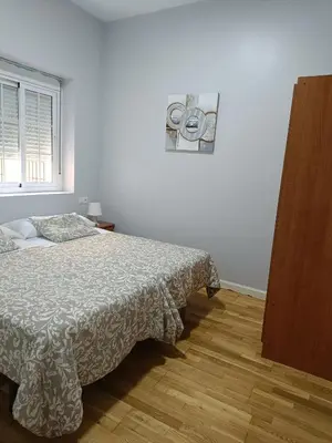 a white bedroom with a bed and a window at Apartamentos Aloha 2 Centro El Puerto de Santa Maria in El Puerto de Santa María
