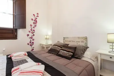 a bedroom with a large bed with blankets and pillows at Casa ALEGRIA by Cadiz4Rentals in Cádiz