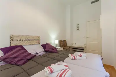 a bedroom with two beds with purple and white pillows at Casa ALEGRIA by Cadiz4Rentals in Cádiz
