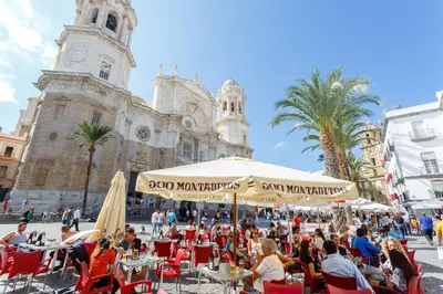 a group of people sitting at tables in front of a building at Casa ALEGRIA by Cadiz4Rentals in Cádiz