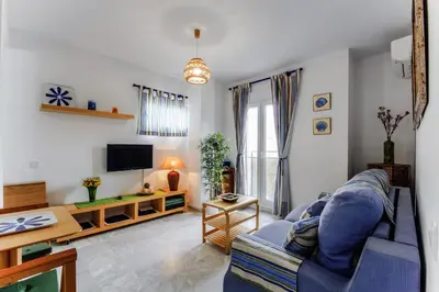 a living room with a blue couch and a tv at La VICTORIA Home free parking by Cadiz4Rentals in Cádiz