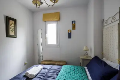 a bedroom with a blue bed and a window at La VICTORIA Home free parking by Cadiz4Rentals in Cádiz