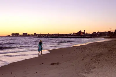 a woman standing on a beach near the ocean at La VICTORIA Home free parking by Cadiz4Rentals in Cádiz