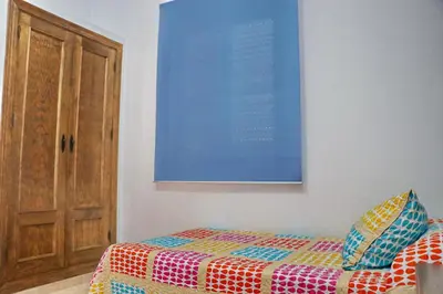 a bedroom with a bed and a painting on the wall at Chalet La Roa III in Conil de la Frontera