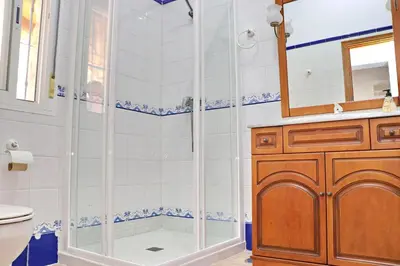 a bathroom with a shower and a toilet and a sink at Chalet La Roa III in Conil de la Frontera