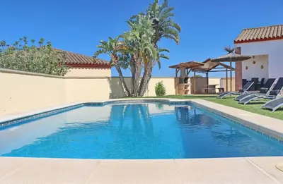 a swimming pool with blue water in a yard at Chalet Vigía 113 in Conil de la Frontera
