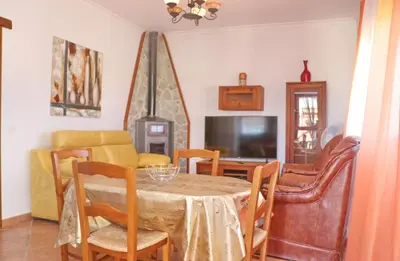a dining room with a table and chairs and a television at Chalet Vigía 113 in Conil de la Frontera