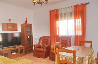 a living room with a table and chairs and a television at Chalet Vigía 113 in Conil de la Frontera