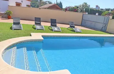 a swimming pool with four chairs in a yard at Chalet Vigía 113 in Conil de la Frontera