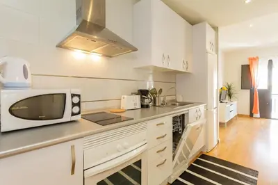 a kitchen with white cabinets and a microwave on a counter at Apartamento La PALMA free parking by Cadiz4Rentals in Cádiz