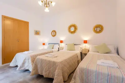 a bedroom with two beds and two mirrors on the wall at El Balcon de MORET by Cadiz4Rentals in Cádiz