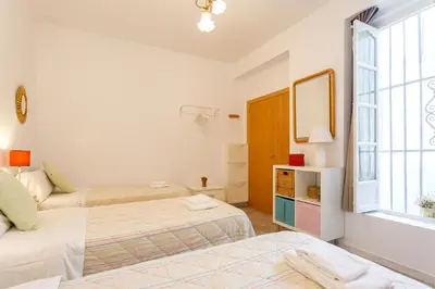 a bedroom with two beds and a window at El Balcon de MORET by Cadiz4Rentals in Cádiz