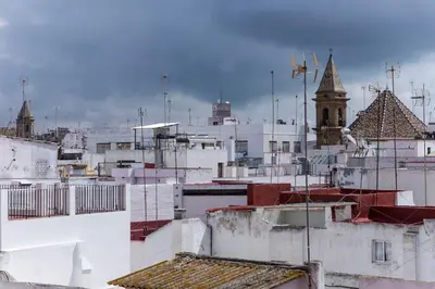 a view of roofs of buildings with a clock tower at Apartamento PUERTA-CALETA by Cadiz4Rentals in Cádiz