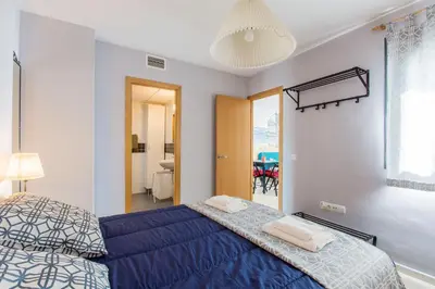 a bedroom with a blue bed and a window at Apartamento PUERTA-CALETA by Cadiz4Rentals in Cádiz