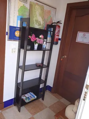 a black book shelf next to a door at Pensión Montero in Jedula