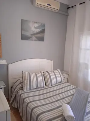 a bedroom with a bed with a striped bedspread at Pensión Montero in Jedula