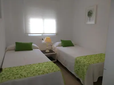 a bedroom with two beds with green sheets at Apartamento Fernández Ladreda in Cádiz