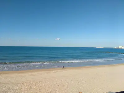 a person walking on a beach near the ocean at Apartamento Fernández Ladreda in Cádiz