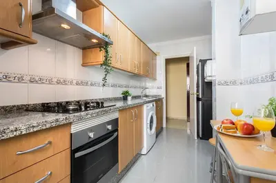a kitchen with a sink and a stove top oven at Brisas Estadio Playa Victoria in Cádiz